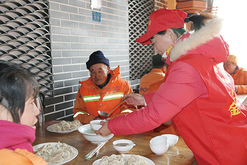 张记老味道疙瘩汤志愿者高兴地为环卫工人盛上饺子汤。.jpg